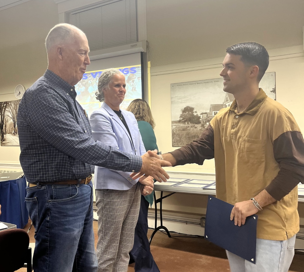 Special education teacher Cameron Decas shakes School Committee Chair Geoffrey Swett's hand. Photos by Tanvi Kulkarni