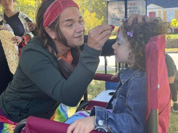 Beth Kelly from Art on the Spot paints a Spiderman design on a young girl's face. She has been facepainting for 15 years. Photos by Tanvi Kulkarni