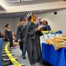 A student collects their diploma at the June graduation ceremony.